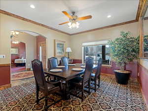 Dining room with arched walkways, recessed lighting, ceiling fan, and ornamental molding