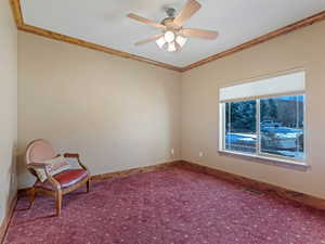 Unfurnished room with visible vents, carpet floors, crown molding, baseboards, and ceiling fan