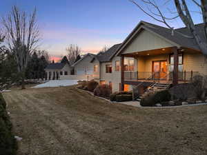 View of front of house with stairs, a front lawn, a garage, and roof with shingles