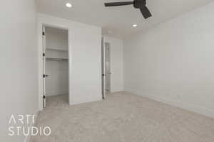 Unfurnished bedroom with recessed lighting, a walk in closet, baseboards, and carpet