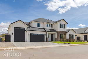 View of front of home with stucco siding, a tiled roof, decorative driveway, and a front yard