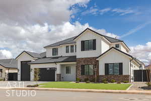 Modern inspired farmhouse with brick siding, a front yard, fence, and board and batten siding