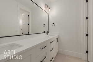 Full bath featuring a sink, baseboards, and double vanity