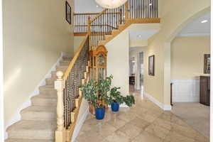 Entryway featuring baseboards, carpet flooring, recessed lighting, a high ceiling, and a decorative wall