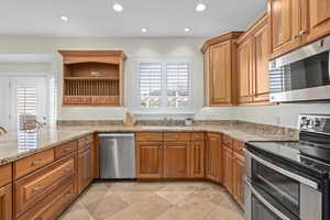 Kitchen featuring open shelves, recessed lighting, appliances with stainless steel finishes, and a sink