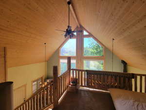 Interior space featuring lofted ceiling with beams, wooden ceiling, and carpet flooring