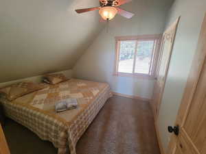 Bedroom featuring carpet floors, ceiling fan, baseboards, and vaulted ceiling