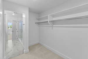 Spacious closet featuring visible vents and marble finish floor