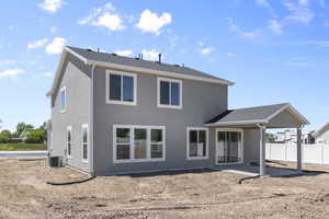 Back of house with central air condition unit, fence, roof with shingles, and a patio area