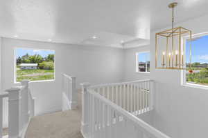 Corridor with baseboards, an upstairs landing, carpet flooring, recessed lighting, and a textured ceiling