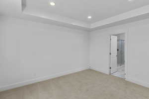 Empty room with recessed lighting, baseboards, carpet, and a raised ceiling