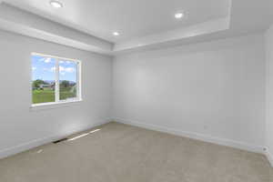 Empty room with recessed lighting, light colored carpet, visible vents, and baseboards