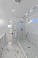 Bathroom featuring visible vents, marble finish floor, a stall shower, and vanity