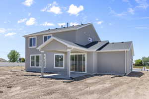 Rear view of property with a patio area, stucco siding, roof with shingles, and fence