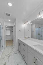 Bathroom with a sink, visible vents, marble finish floor, and a shower stall