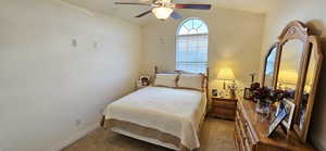 Carpeted bedroom with baseboards, lofted ceiling, and ceiling fan