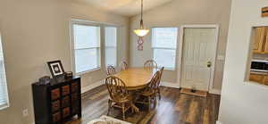 Dining area featuring baseboards, lofted ceiling, and dark wood-style flooring