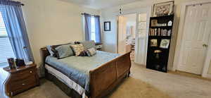 Bedroom featuring light colored carpet and ensuite bathroom