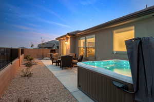 View of patio featuring a fenced backyard and a hot tub