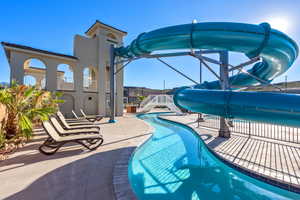 Pool with stairway, a patio, and a water slide