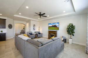 Living area with visible vents, recessed lighting, a fireplace, and a raised ceiling