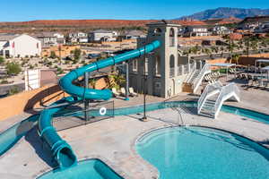 Community pool with a patio, a residential view, a mountain view, and a water slide