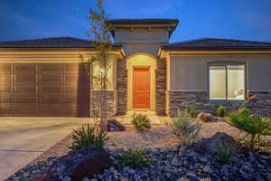 Prairie-style house with a garage, stone siding, and driveway