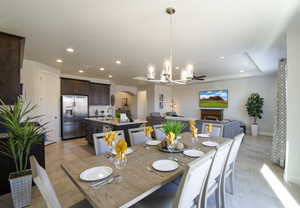 Dining area with baseboards, a fireplace, recessed lighting, arched walkways, and a notable chandelier