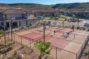 View of tennis court featuring a residential view, a mountain view, and fence