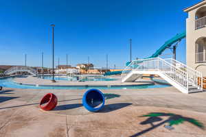 Community pool with stairs and a patio area