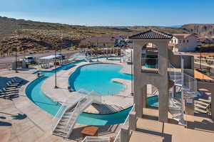 Community pool with stairway, a mountain view, and a patio