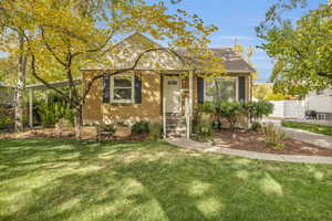 View of front of house featuring brick siding, a front lawn, and fence