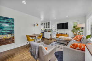 Living room featuring recessed lighting, baseboards, wood finished floors, and crown molding