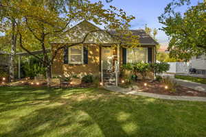 Bungalow-style house featuring brick siding, a front lawn, and fence