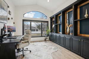 Home office featuring vaulted ceiling and light wood-style floors