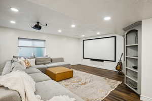 Home theater featuring recessed lighting, baseboards, a textured ceiling, and dark wood-style flooring