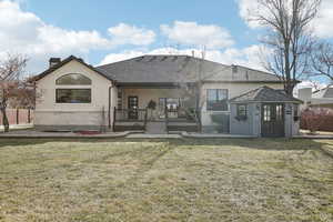 Rear view of house featuring brick siding, stucco siding, and a yard