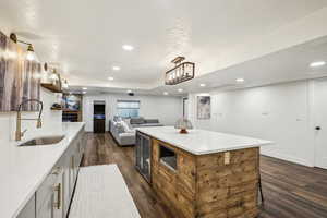 Kitchen featuring dark wood finished floors, light countertops, a textured ceiling, and a sink