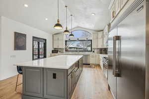 Kitchen with light countertops, a healthy amount of sunlight, appliances with stainless steel finishes, and gray cabinetry