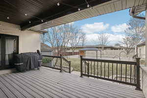 Wooden terrace featuring a gazebo, a yard, a grill, and fence