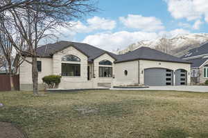 French country home featuring a front lawn, concrete driveway, and brick siding