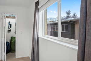 Corridor with a mountain view, baseboards, and light colored carpet