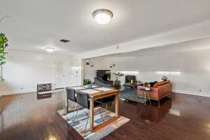 Interior space featuring visible vents, wood-type flooring, and baseboards