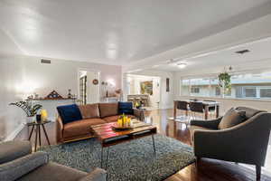 Living area featuring hardwood / wood-style floors, baseboards, and visible vents