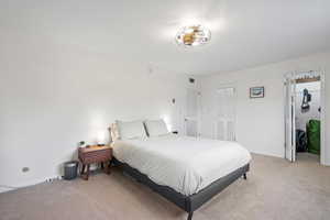 Bedroom with visible vents, light colored carpet, and baseboards