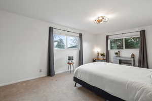 Bedroom featuring baseboards and light carpet