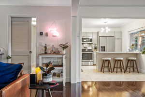 Kitchen featuring tasteful backsplash, pendant lighting, a breakfast bar area, light wood-style flooring, and appliances with stainless steel finishes