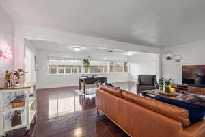 Living area featuring baseboards and dark wood-style flooring