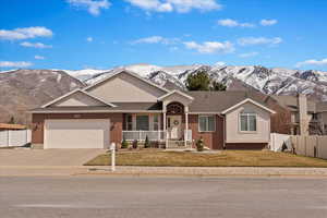 Rambler plan with fenced backyard, mountain views, mature yard, RV parking, brick and stucco exterior.