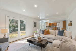 Living room with view of kitchen and french doors to backyard.